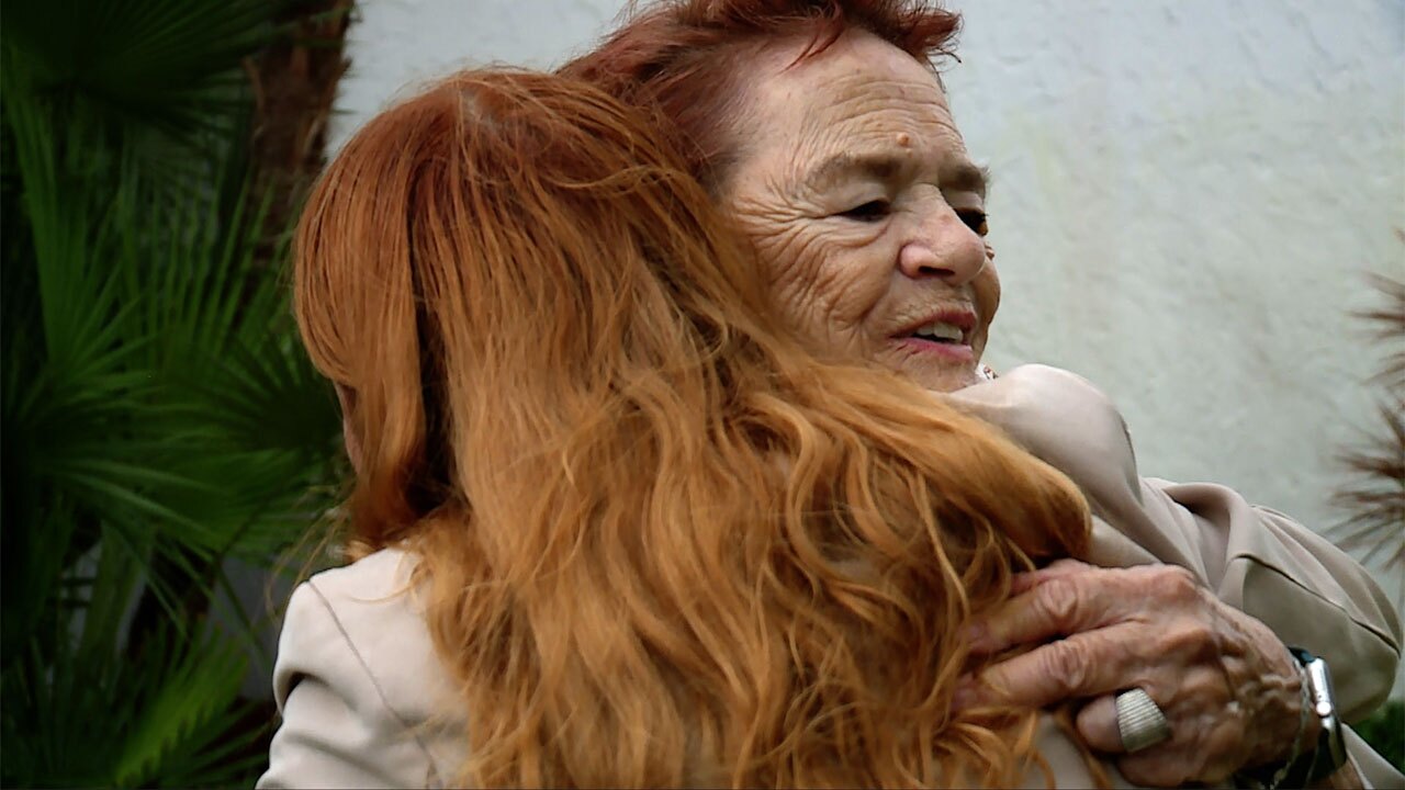 Rosie Quaranta embraces WPTV reporter Kate Hussey after the emotional memorial at Spanish Lakes, reflecting on the loss and resilience of the community one year after the EF3 tornado.