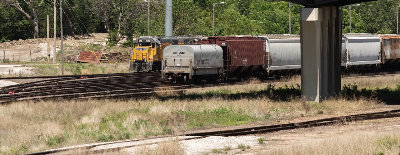 two trains pass under an overpass