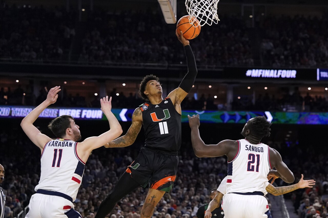 Miami Hurricanes guard Jordan Miller shoots over Connecticut Huskies forwards Alex Karaban and Adama Sanogo in first half of Final Four, April 1, 2023