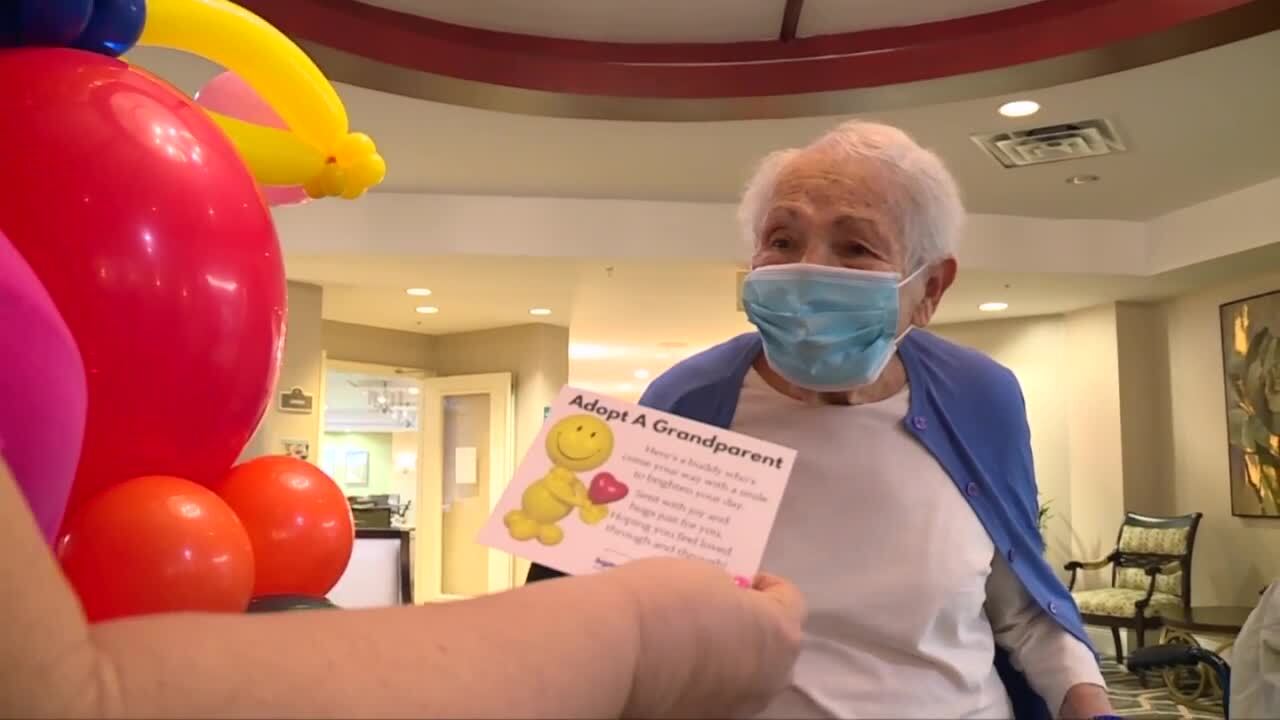 Lenor Ryan presents 'Adopt a Grandparent' card to resident at Discovery Village at Boynton Beach
