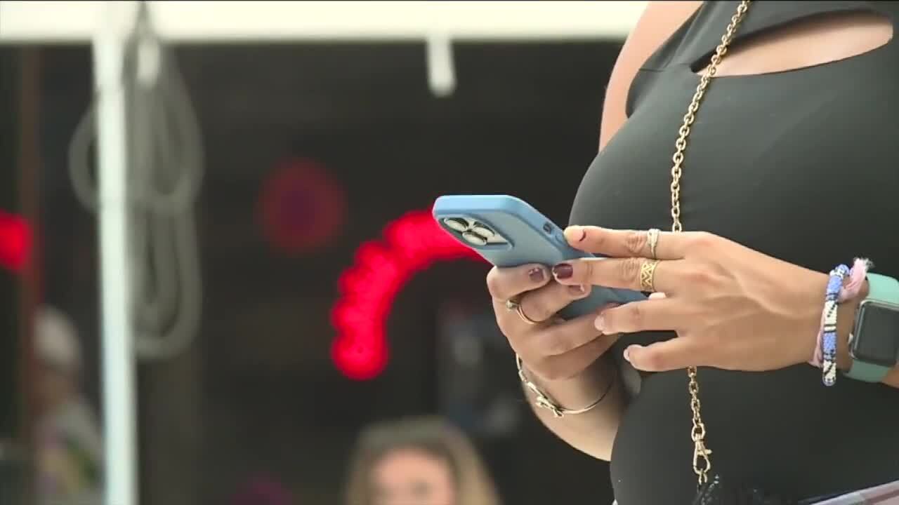 woman holds cellphone while standing outside