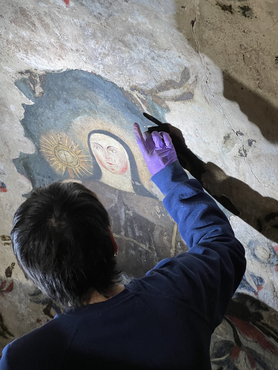 Conservation technician working to restore painting on main dome wall