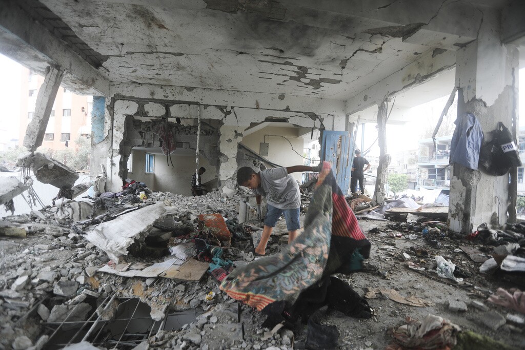 Palestinians look at the aftermath of the Israeli strike on a U.N.-run school that killed dozens of people in the Nusseirat refugee camp in the Gaza Strip