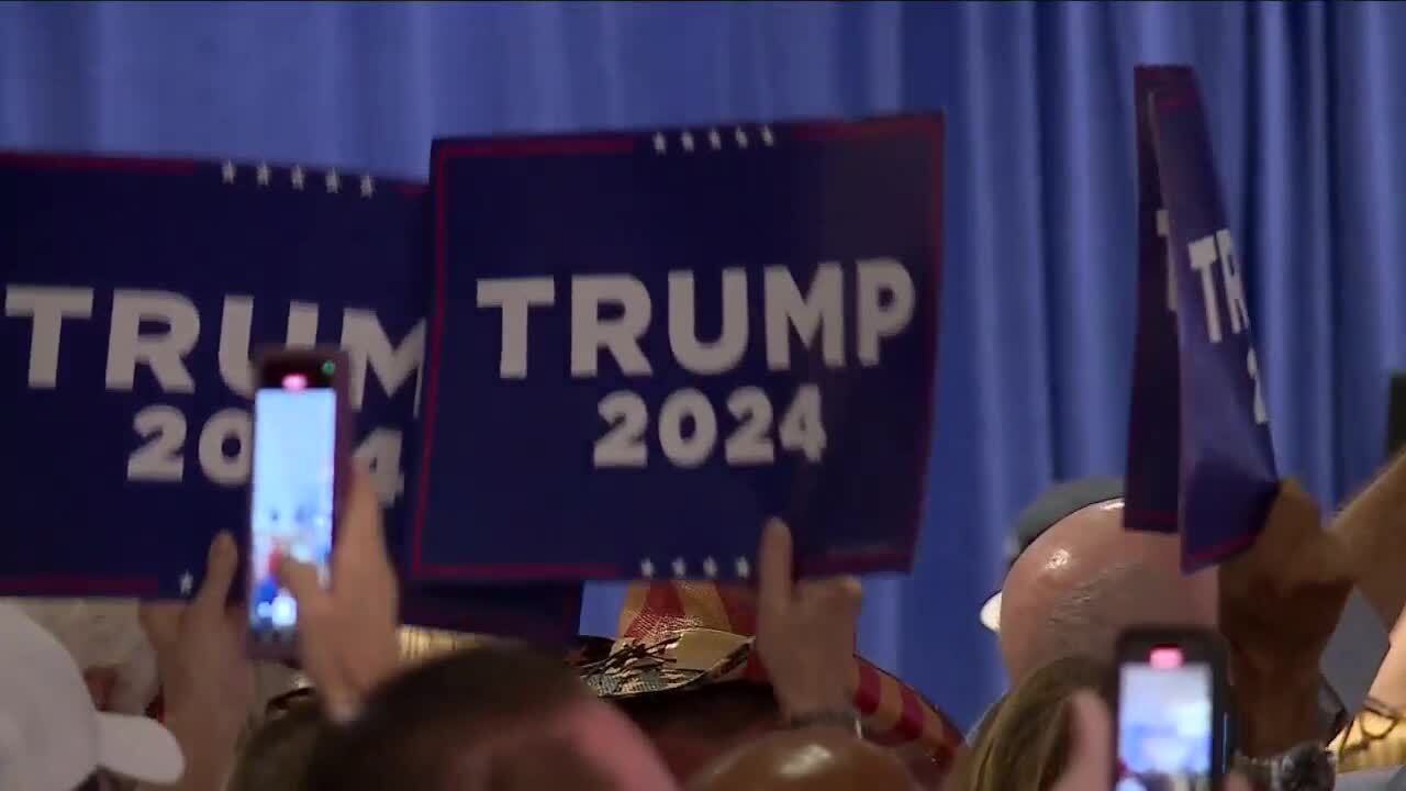 Supporters wave 'Trump 2024' posters in room where Donald Trump speaks, Feb. 20, 2023