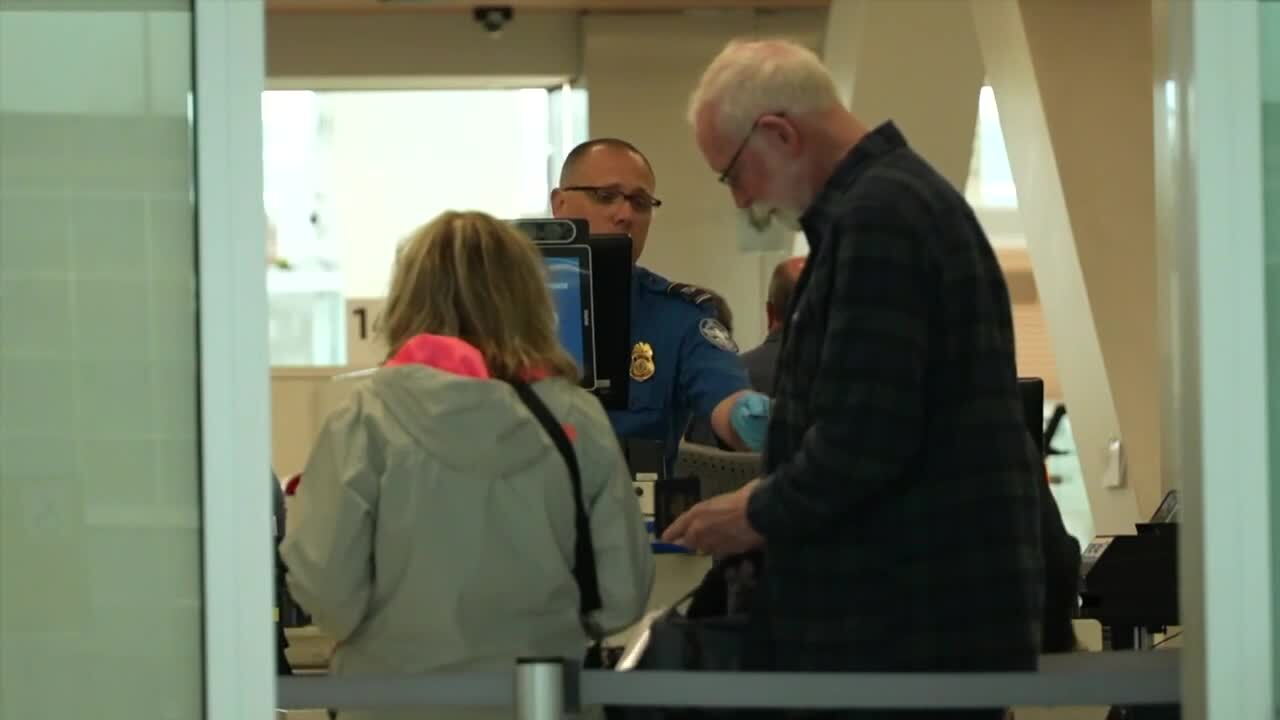 Travelers move through a security line at Denver International Airport.