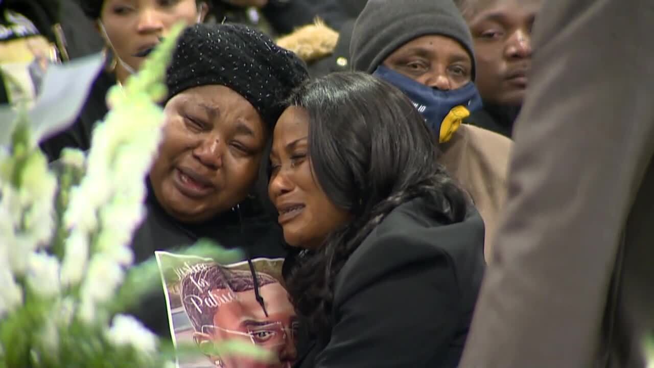 Lyoya mom crying at funeral with justice for patrick pic.jpg