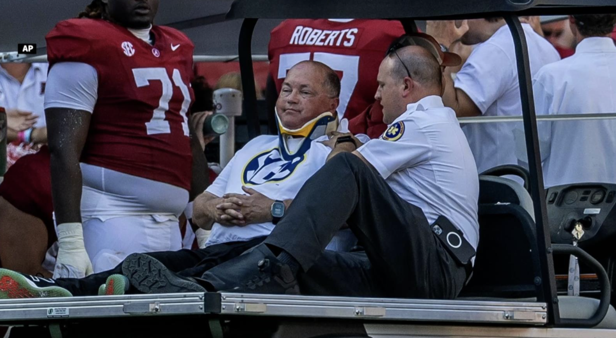 An Associated Press photo shows sideline official Kirby Michaels being carted off the field after a collision with a player in September at Alabama.