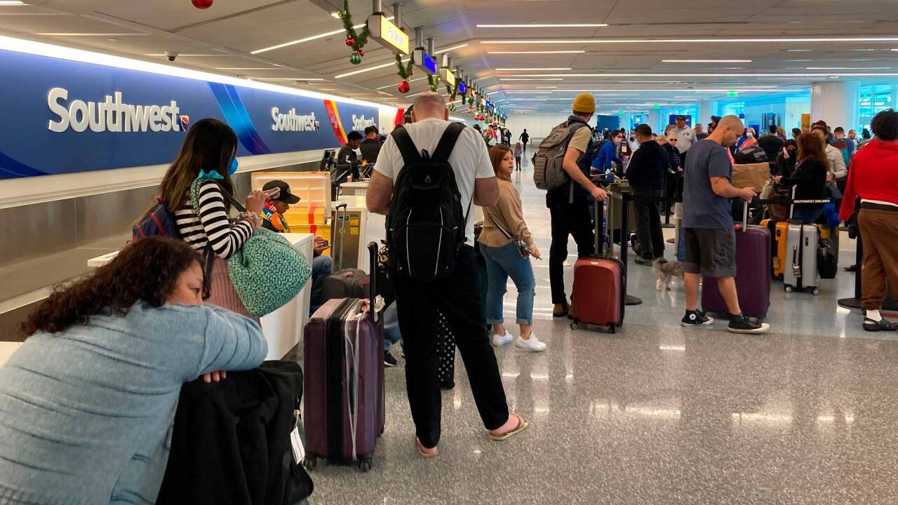 Travelers wait at a Southwest Airlines baggage counter to retrieve their bags after canceled flights at Los Angeles International Airport, Monday, Dec. 26, 2022, in Los Angeles.