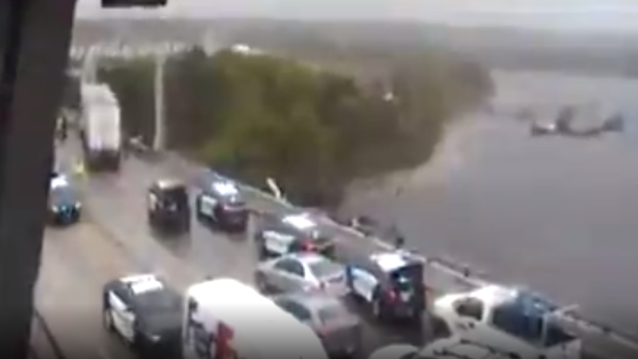 Tractor trailer cab partially hanging off side of High Rise Bridge