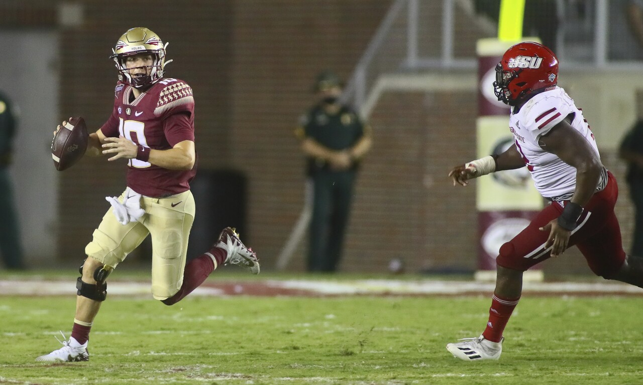 Florida State Seminoles QB McKenzie Milton scrambles from Jacksonville State Gamecocks defensive end Umstead Sanders in 2021