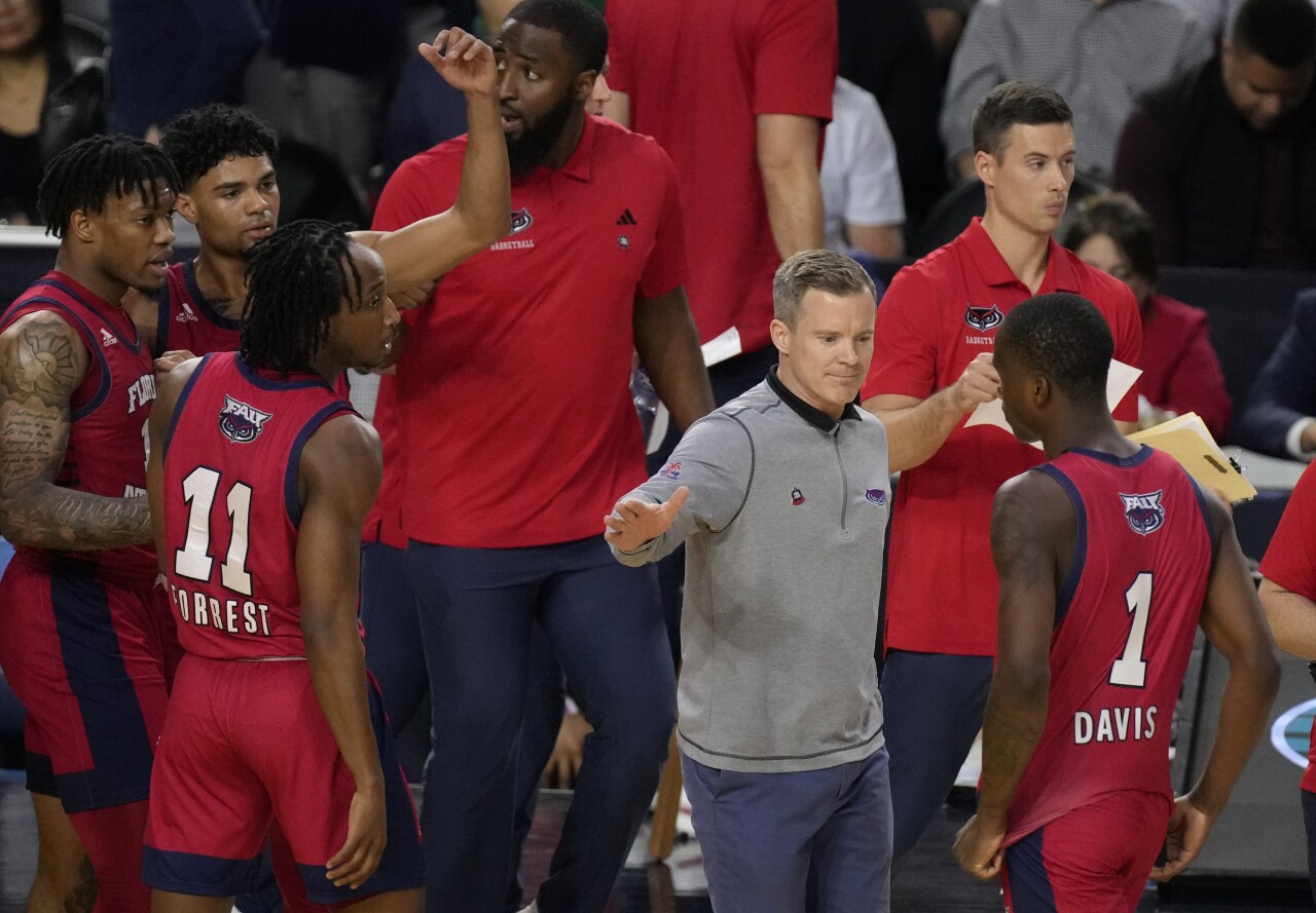 Florida Atlantic Owls head coach Dusty May reaches out to slap hand of guard Johnell Davis during first half of Final Four game, April 1, 2023