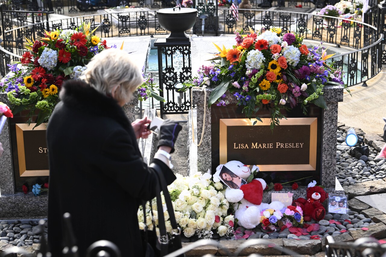 Visitor takes photo at gravesite of Lisa Marie Presley after Graceland memorial, Jan. 22, 2023