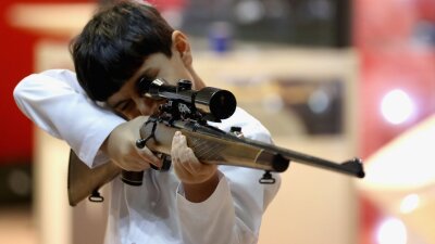 A boy inspects a rifle during The International Hunting and Equestrian Exhibition