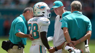 Miami Dolphins running back De'von Achane (28) stands with the coaching staff after an injury during the first half of an NFL football game against the Kansas City Chiefs in Miami Gardens, Fla., Sunday, Sept. 27, 2026. (AP Photo/Lynne Sladky)