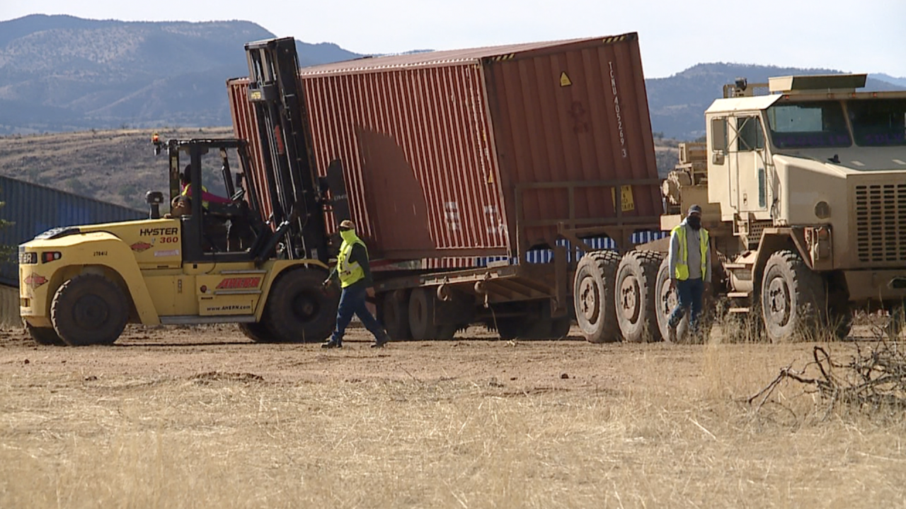 Contractors load a shipping container onto a truck as part of the removal of the makeshift border wall between Arizona and Mexico.