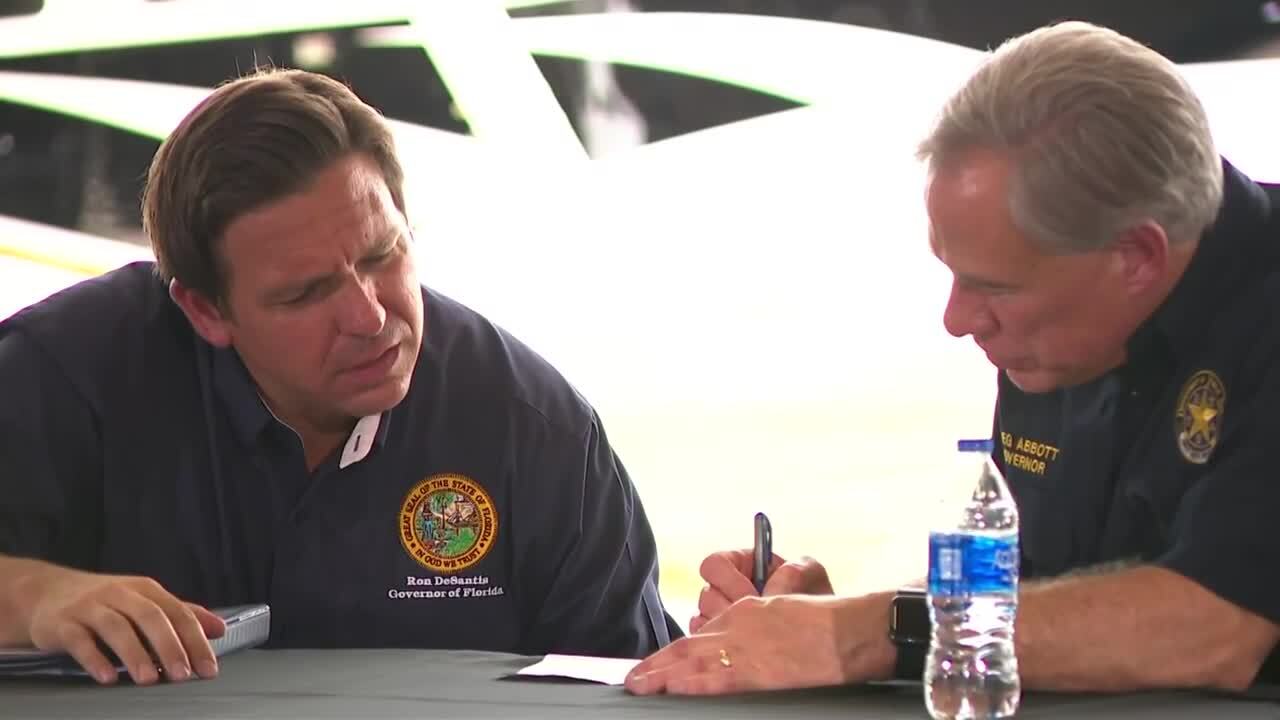 Florida Gov. Ron DeSantis watches as Texas Gov. Greg Abbott writes, July 17, 2021