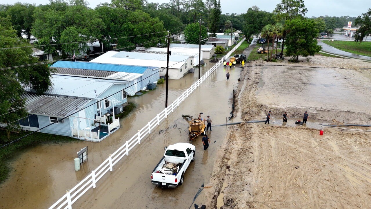Crews knee deep in water working to pump it away from the homes in Moss Landings.