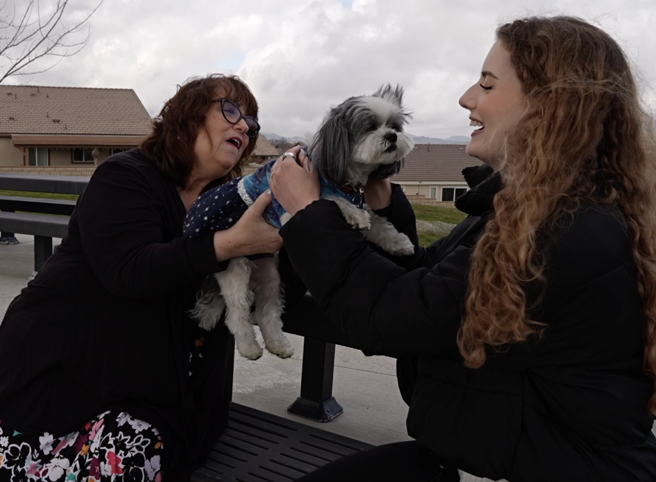 Neighborhood News Reporter Grace Laverriere talking with Teresa Champieux & her dog, Bella