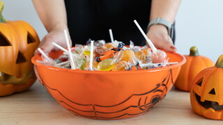 Woman,Holding,A,Halloween,Candy,Bowl,Filled,With,Sweets,For