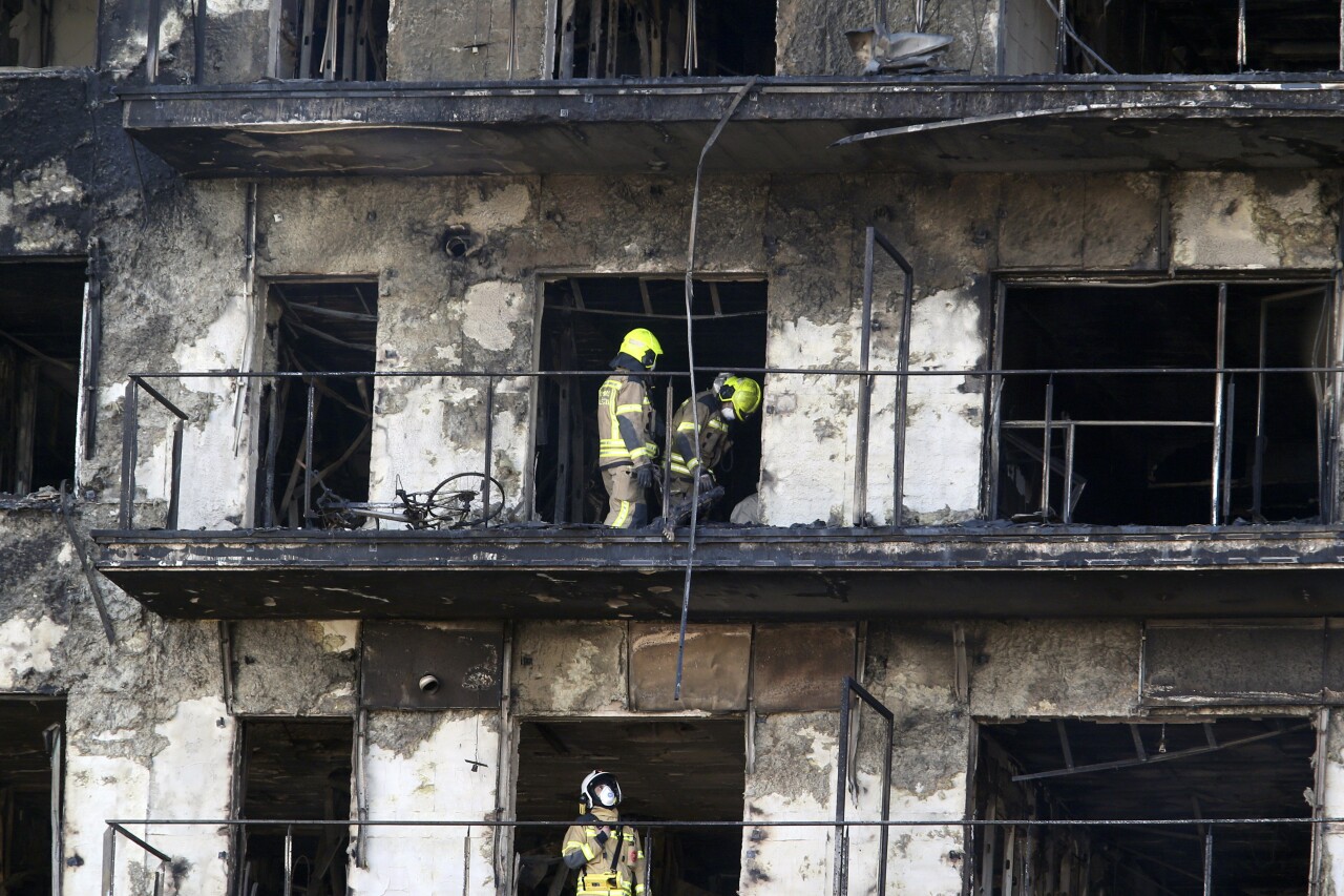 Firefighters remove charred body inside burned block building in Valencia, Spain, Feb. 23, 2024