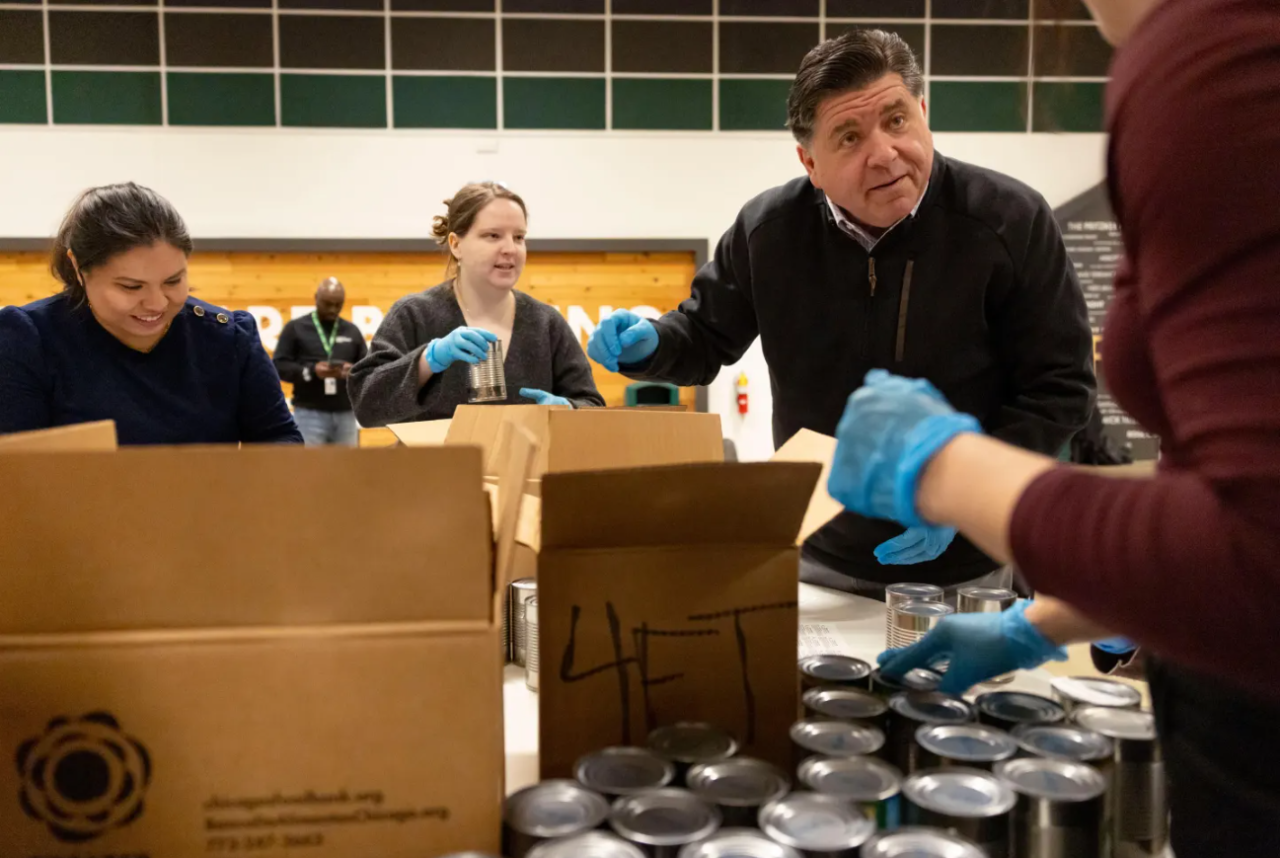Gov. JB Prtizker packs boxes of canned goods with members of his staff while volunteering Thursday, Dec. 4, 2025, at the Greater Chicago Food Depository.