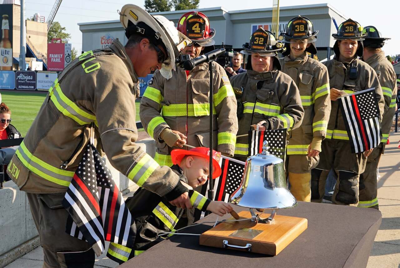 Fire fighters in full gear - boy ringing bell - Grand Rapids 9.11 Memorial Stair Climb