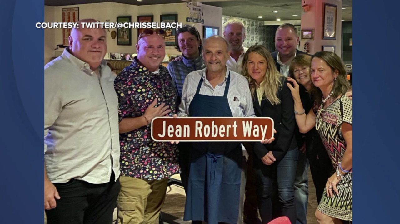 Friends and family celebrate an honorary street sign for chef Jean-Robert de Cavel.
