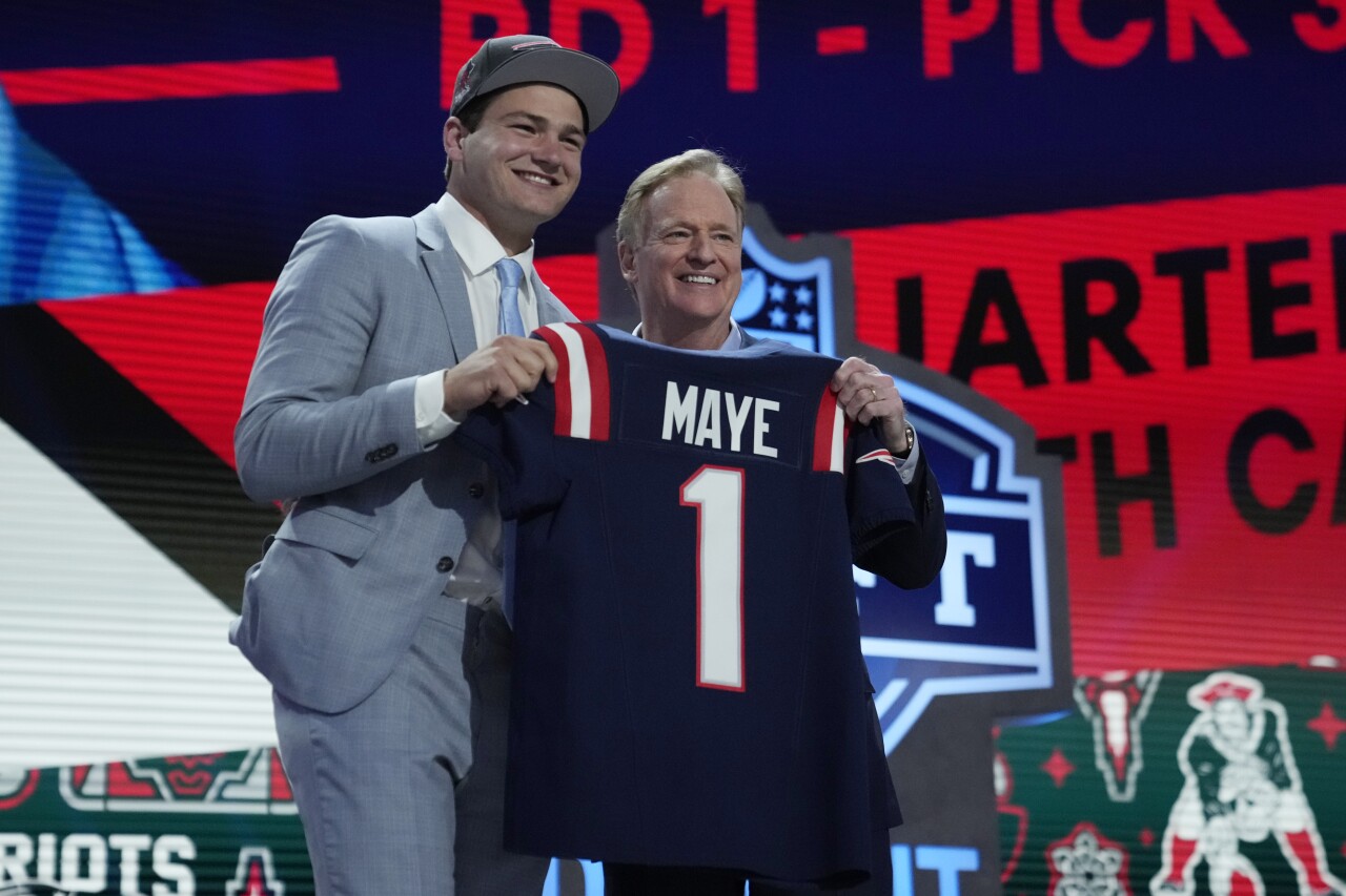 North Carolina Tar Heels QB Drake Maye holds New England Patriots jersey with NFL Commissioner Roger Goodell at 2024 NFL Draft