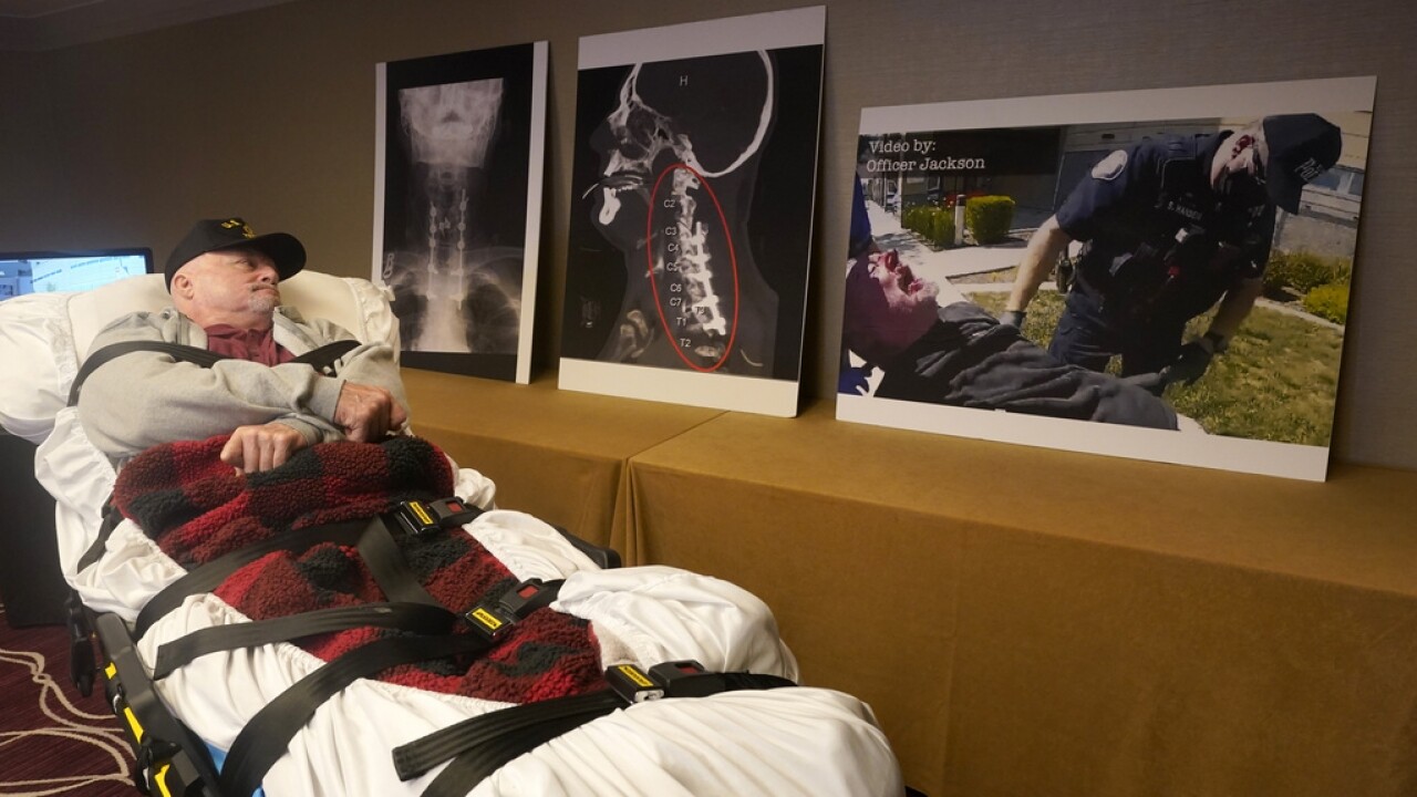 Gregory Gross looks at an enlargement of a video frame of his arrest by Yuba City, Calif., Police