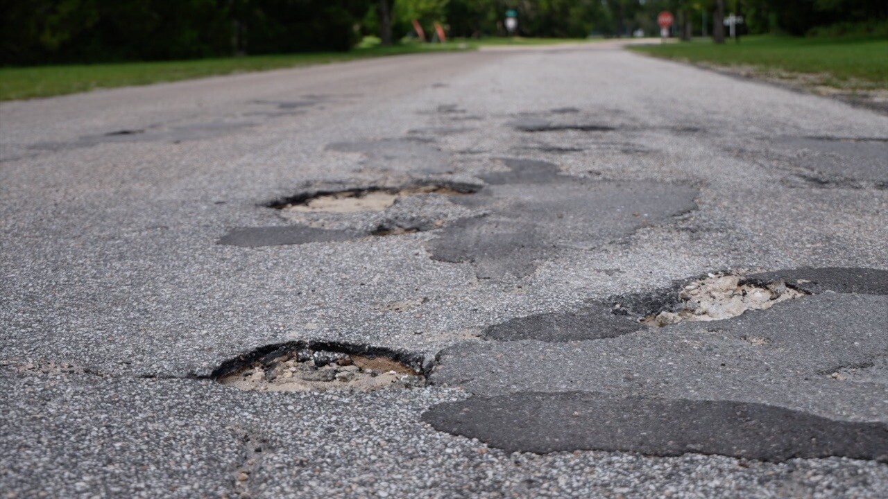 Pothole filled road in LaBelle's Country Village neighborhood.