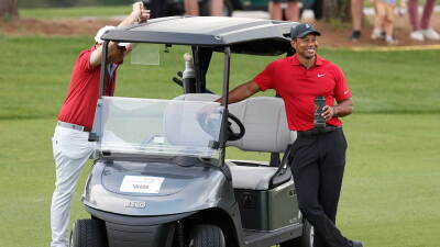 Tiger Woods stands with his cart on the third fairway during the second round of the PNC Championship golf tournament Sunday, Dec. 19, 2021, in Orlando, Fla. (AP Photo/Scott Audette)