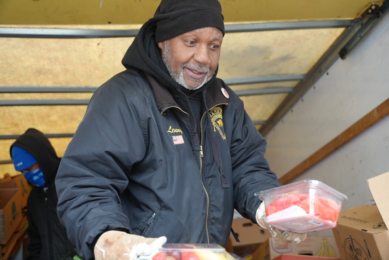 Lane giving out fruit to families on Broadway in Buffalo