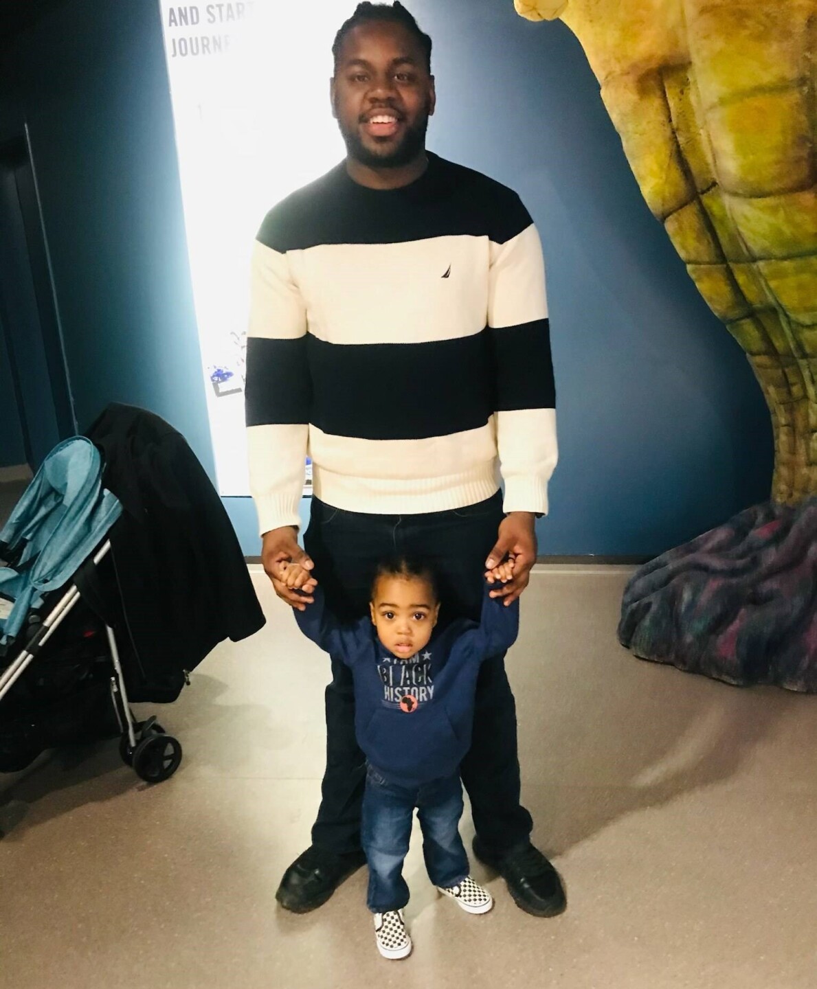 Rodney Walker is standing and holding his young son's hands in this photo.