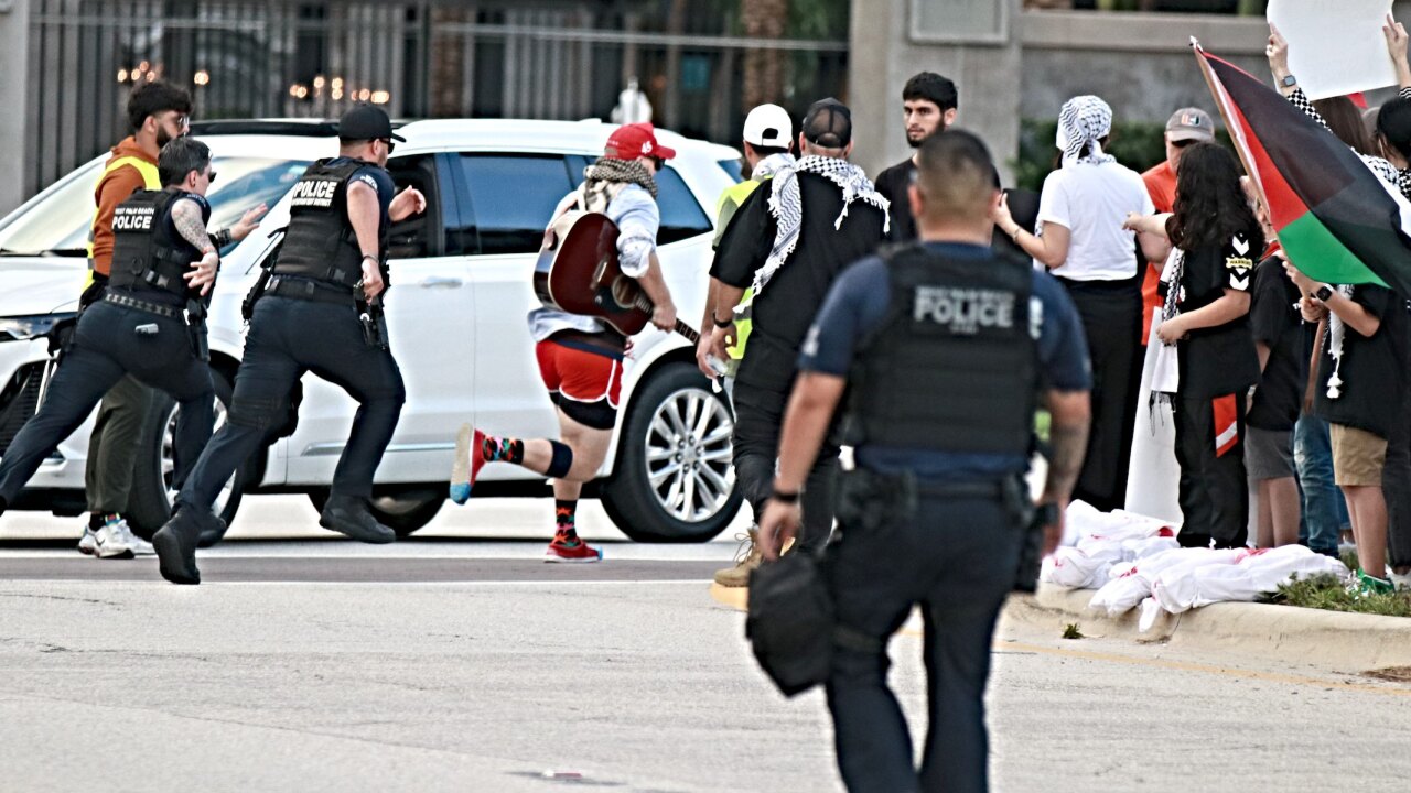 Photos provided by the West Palm Beach Police Department on Nov. 19, 2023, show Hawazin Gridley Wright running in a street while carrying a guitar as officers chased him.