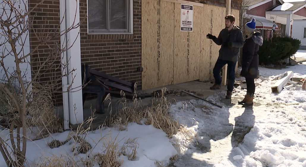 Noah Bowles showing the damage to the front of his home
