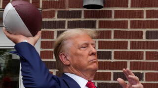 Former President Donald Trump throws a football to the crowd during a visit to the Alpha Gamma Rho, agricultural fraternity, at Iowa State University before an NCAA college football game between Iowa State and Iowa, Saturday, Sept. 9, 2023, in Ames, Iowa.
