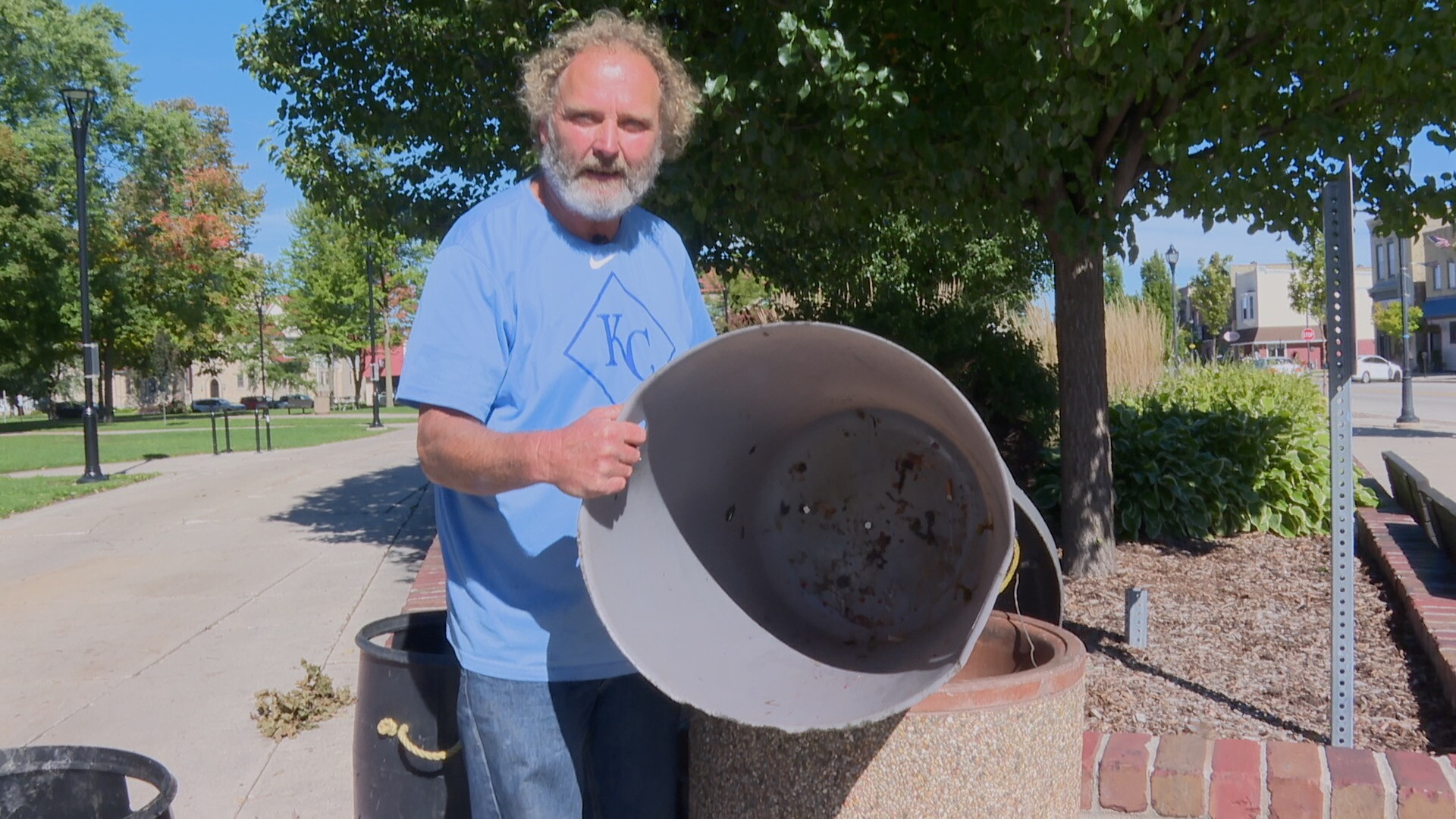 Paul, also known as Road Runner, cleans the litter bin at a Sheboygan Park