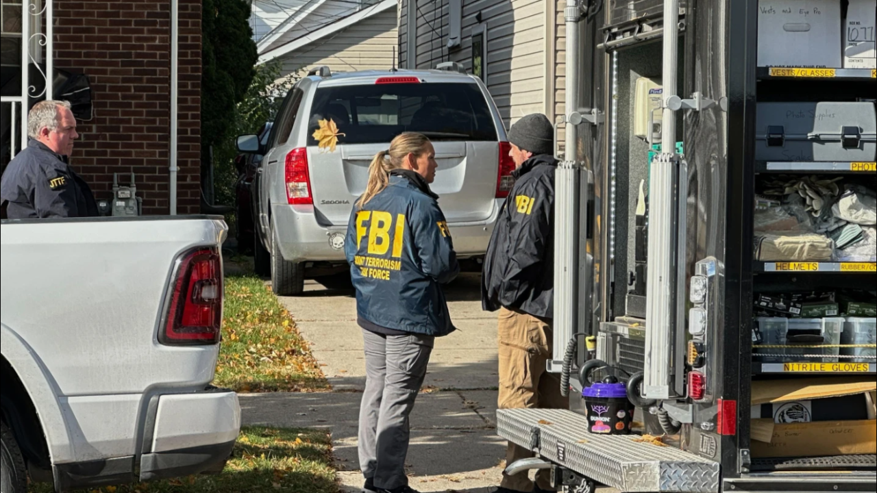 FBI agents gather outside a home in a Dearborn, Mich., neighborhood on Friday, Oct. 31, 2025. 