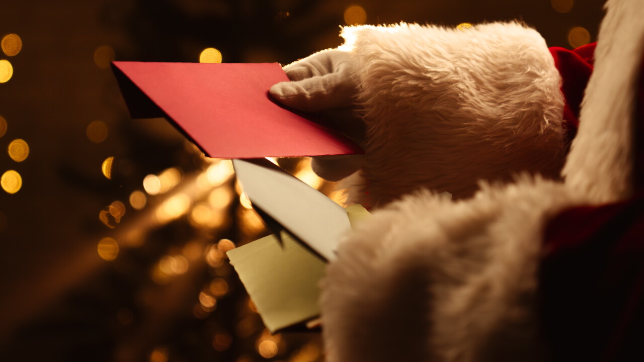 Santa,Claus,Looks,Through,Envelopes,With,Letters,Near,A,Sparkling
