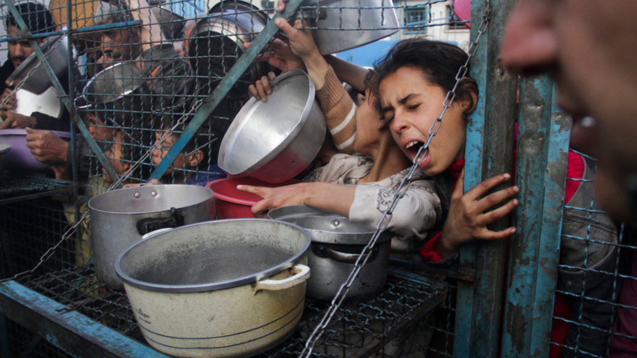 Palestinians line up to receive meals at Jabaliya refugee camp in the Gaza Strip