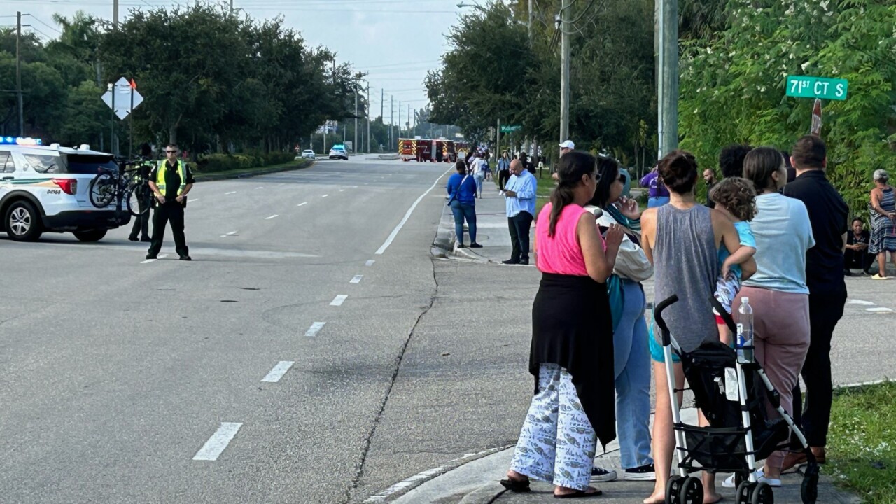 Parents and guardians gather near Hidden Oaks K-8 School, west of Boynton Beach, on Aug. 25, 2023, following an unfounded report of a student with a gun.jpg