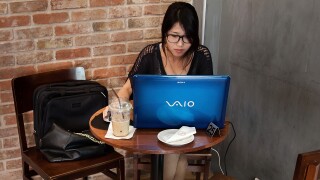 A woman using her VAIO laptop at a coffee shop.