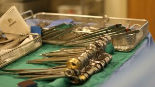 Surgical tools are seen on a surgical table.