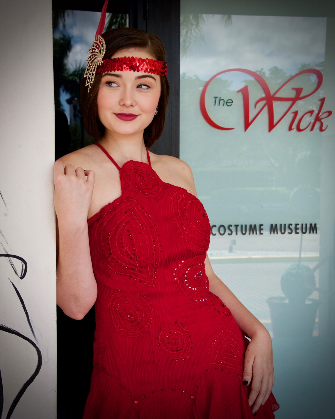 Woman in a 1920's style red dress and headband.