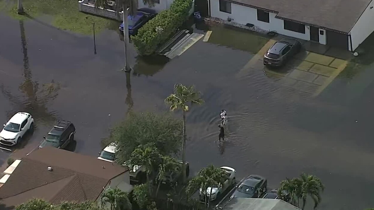 Residents walk through flooded street in Fort Lauderdale neighborhood on April 13, 2023