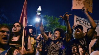 Demonstrators gather near to the Wells Fargo Centre on day four of the Democratic National Convention.