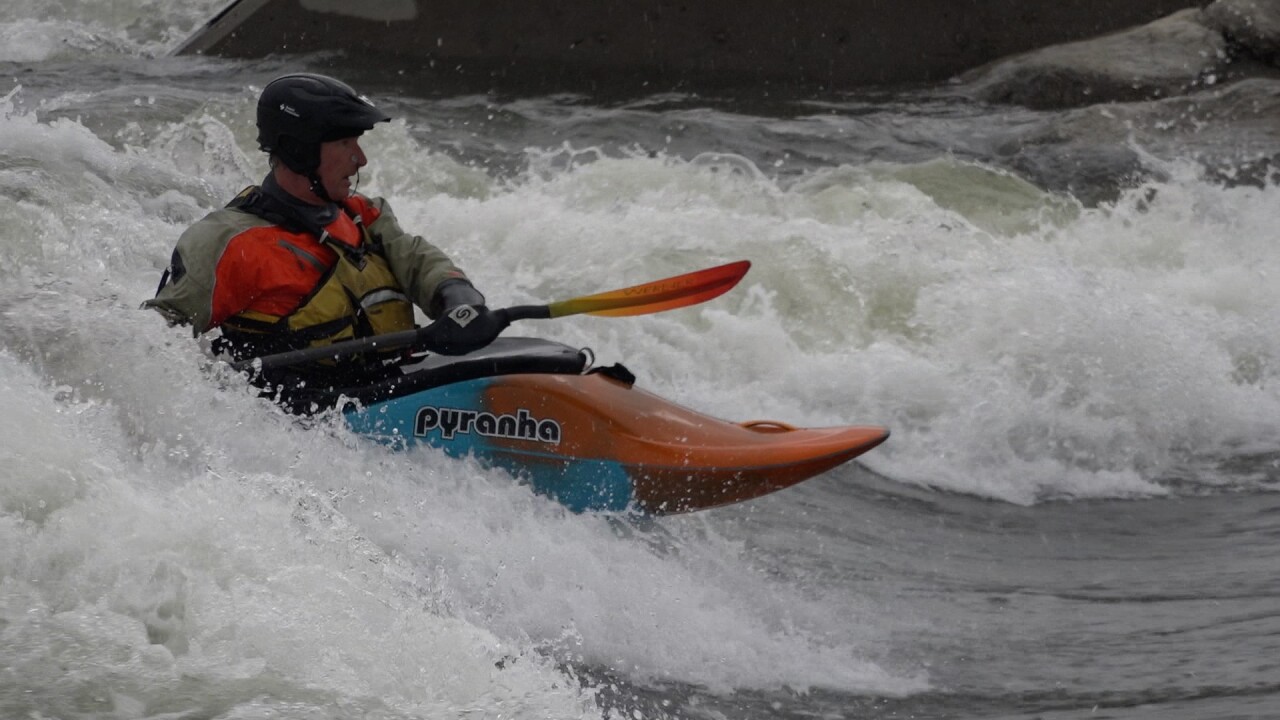 A kayaker surfs at the Whitewater Park