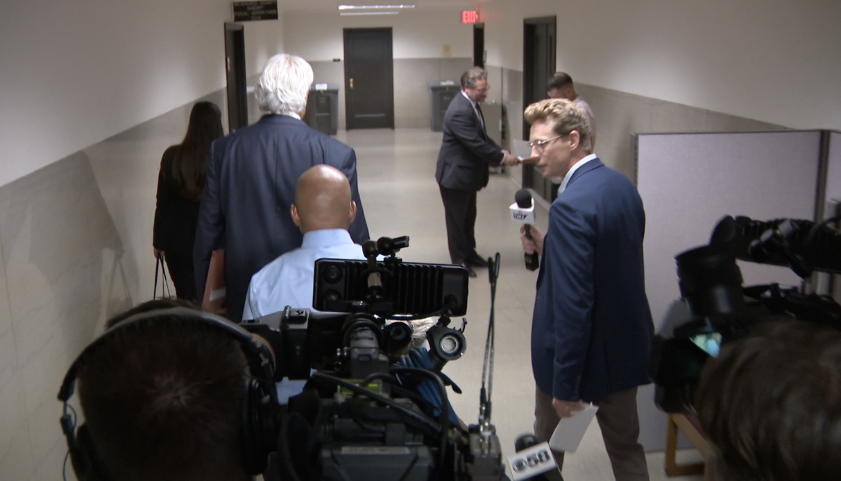 Chapman walking by reporters.png