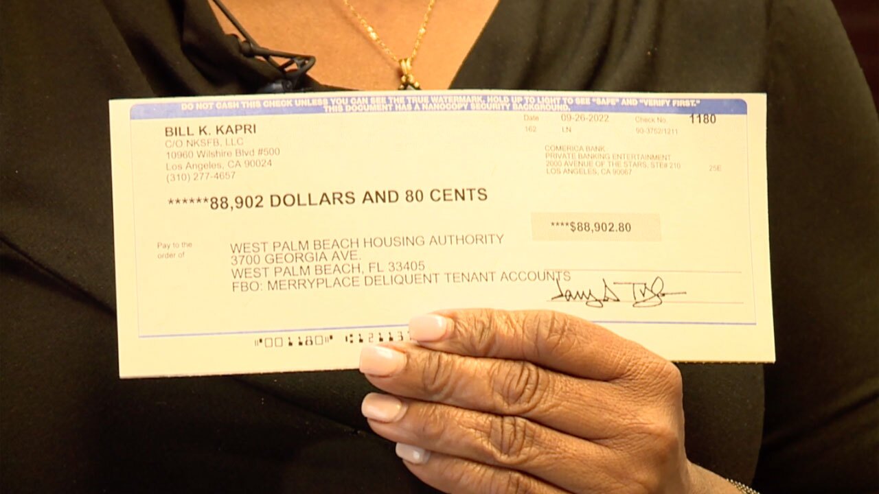 Linda Odum of the West Palm Beach Housing Authority shows off a check for $88,902.80 donated by Kodak Black and the Zachariah McQueen Foundation to help pay the rent of residents facing eviction.