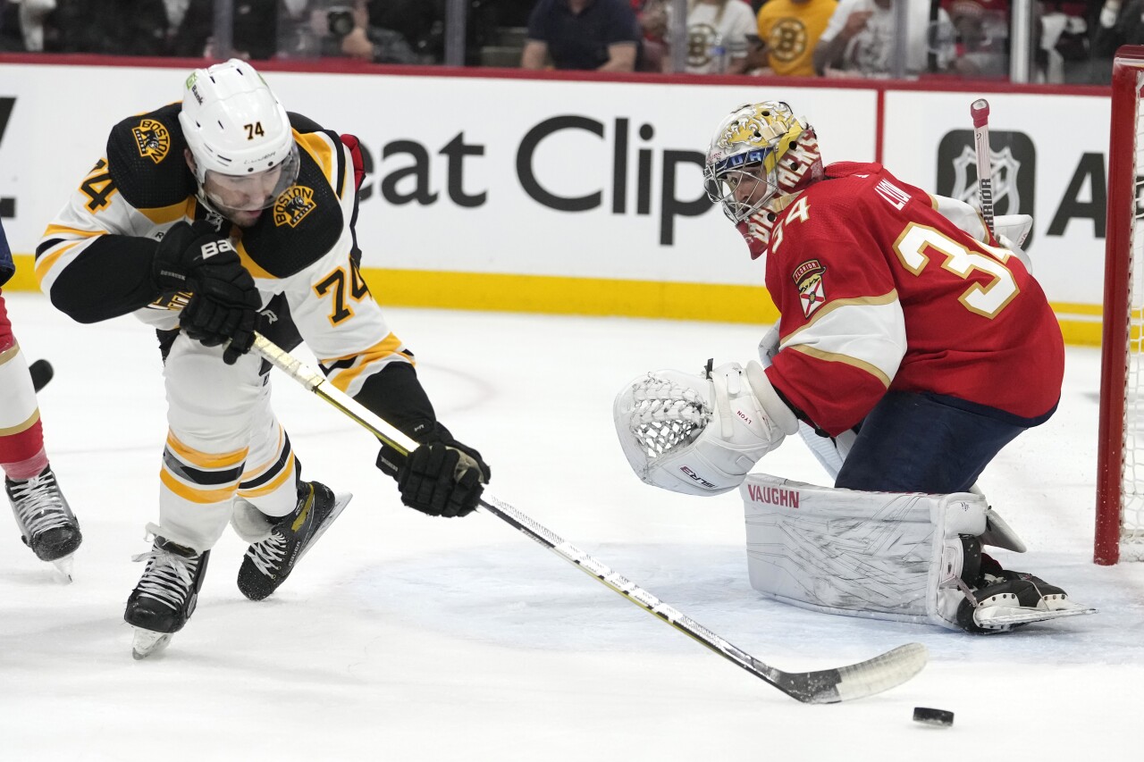 Boston Bruins left wing Jake DeBrusk passes puck as Florida Panthers goaltender Alex Lyon defends during first round of NHL playoff series, April 21, 2023